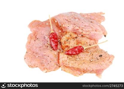 raw pork meat with red pepper ready to be cooked (over white)