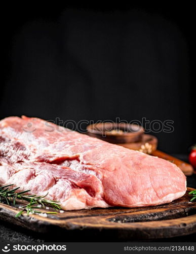 Raw pork on a cutting board. On a black background. High quality photo. Raw pork on a cutting board.