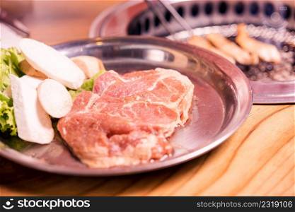 Raw pork on plate, Korean traditional style fresh pork beef belly BBQ on stove serve wood table, Japanese meat hot pot or Shabu in the restaurant, barbecue food