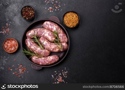 Raw pork sausages grill with spices and herbs on a dark concrete table. Cooking at home. Raw pork sausages grill with spices and herbs on a dark concrete table