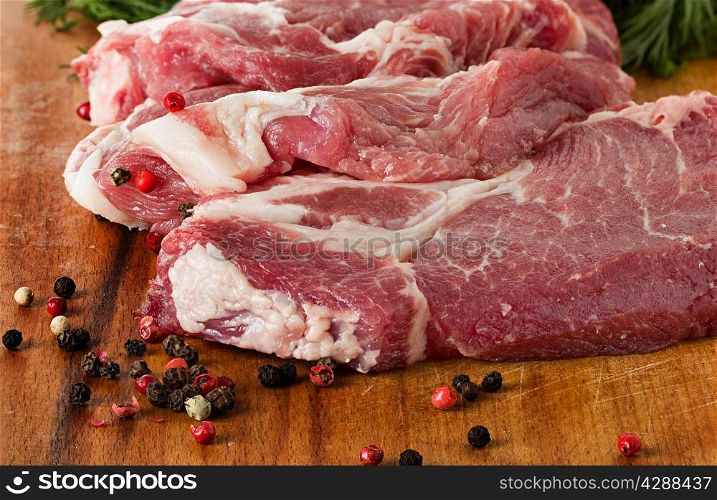Raw pork steak on a dark wooden table