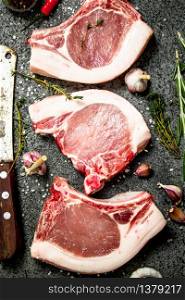 Raw pork steak with a sprig of rosemary and spices. On rustic background.. Raw pork steak with a sprig of rosemary and spices.