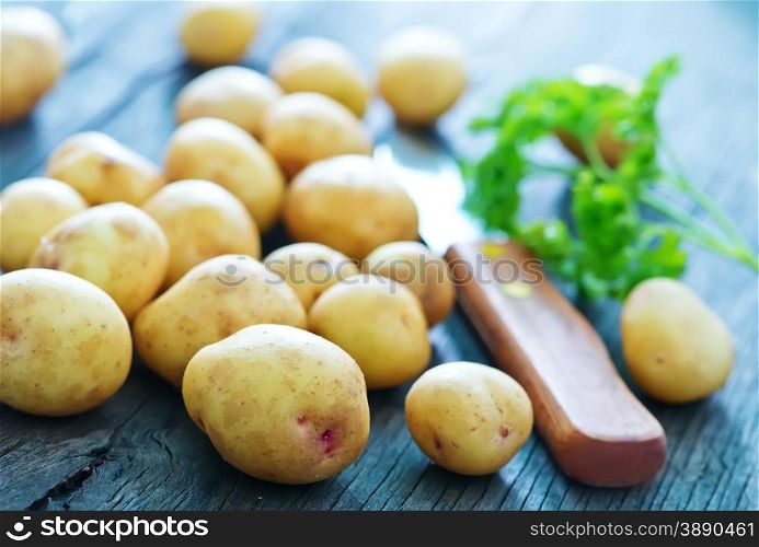 raw potato and knife on the wooden board