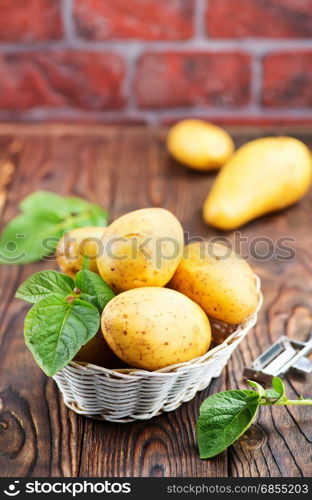 raw potato in basket and on a table