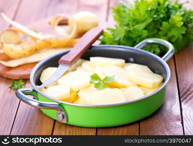 raw potato in bowl and on a table