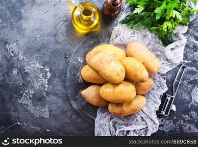 raw potato on plate and on a table