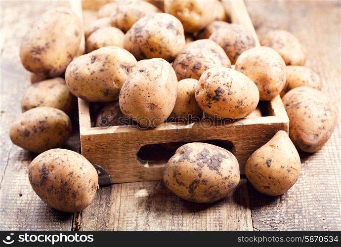 raw potatoes in the wooden box