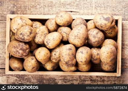 raw potatoes in the wooden box