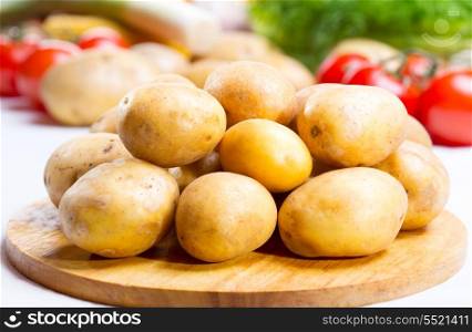 raw potatoes on wooden board