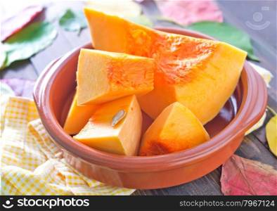 raw pumpkin in bowl and on a table