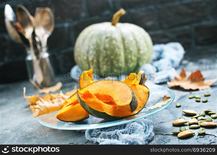 raw pumpkin on plate and on a table
