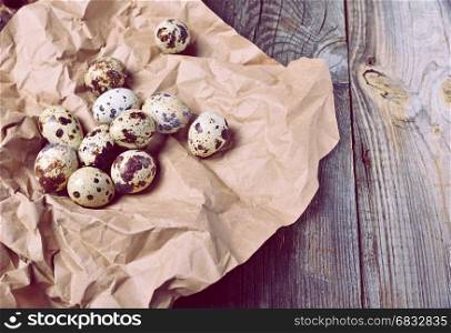 Raw quail eggs on brown kraft paper, empty space on the right