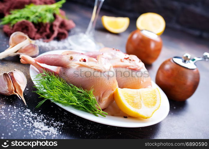 raw quail with salt and lemon on plate