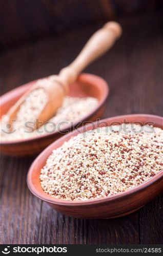 raw quinoa in the brown bowl and on a table