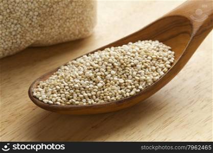 Raw Quinoa seeds on a wooden spoon