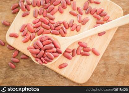 Raw red kidney bean on wooden table, stock photo