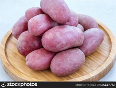 Raw red potatoes on the wooden tray