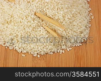 raw rice and chopsticks on bamboo board