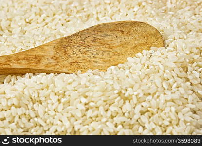 raw rice and wooden spoon