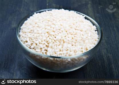 raw rice in glass bowl on wood table