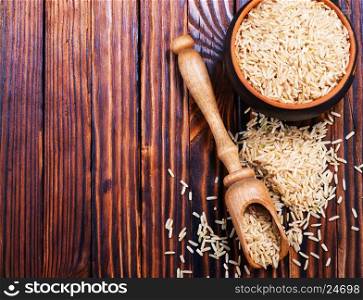 raw rice in wooden spoon and on a table