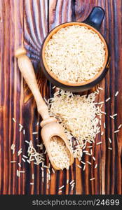 raw rice in wooden spoon and on a table