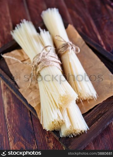 raw rice noodles on the wooden board and on a table