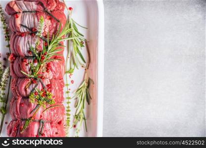 Raw roast beef tied with a rope , cooking preparation with herbs and spices, top view, place for text