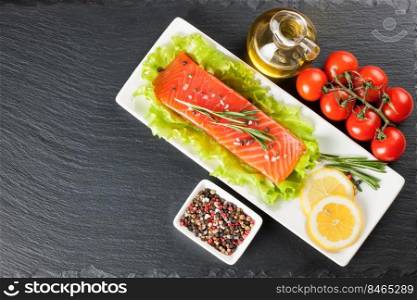 Raw salmon fil≤t, sπces and ve≥tab≤s on a white plate. Top view.. Raw salmon fil≤t