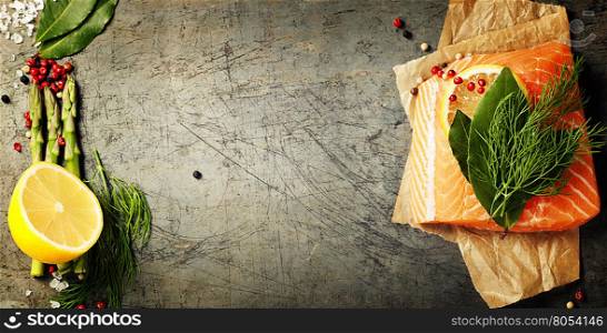 Raw salmon fillet and ingredients for cooking in a rustic style. Top view