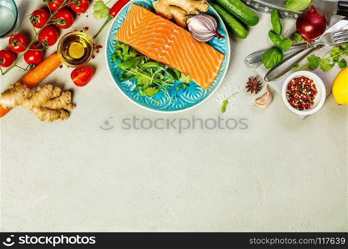 Raw salmon fillet and ingredients for cooking on concrete background in a rustic style. Top view