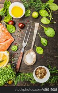 Raw salmon fillet , preparation with fresh seasoning, oil and lemon on rustic wooden background, top view.
