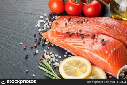 Raw salmon fillet, spices and vegetables on a dark  slate background . Raw salmon fillet 