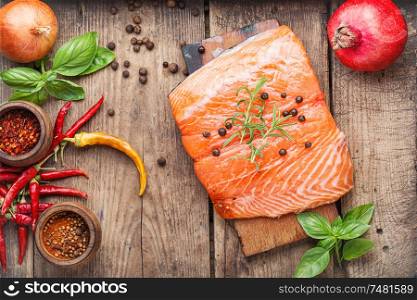 Raw salmon fillet with rosemary on wooden cutting board. Fresh raw salmon fish