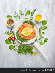 raw salmon in white pan with lemon and fresh herbs, top view