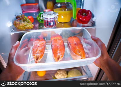 Raw Salmon steak in the open refrigerator