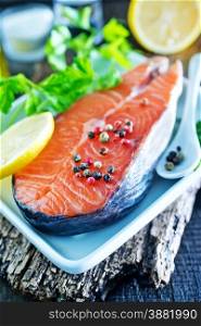 raw salmon with spice and lemon on the wooden board