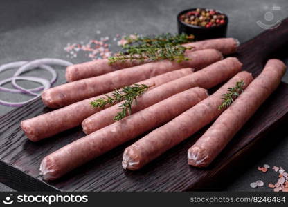 Raw sausages and ingredients for cooking. Top view with copy space on stone table. Raw sausages with spices on a wooden cutting board on a stone background with copy space for your text