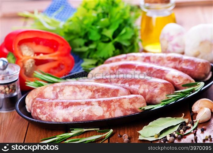 raw sausages on plate and on a table