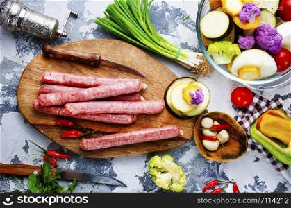 raw sausages with aroma spice on wooden board