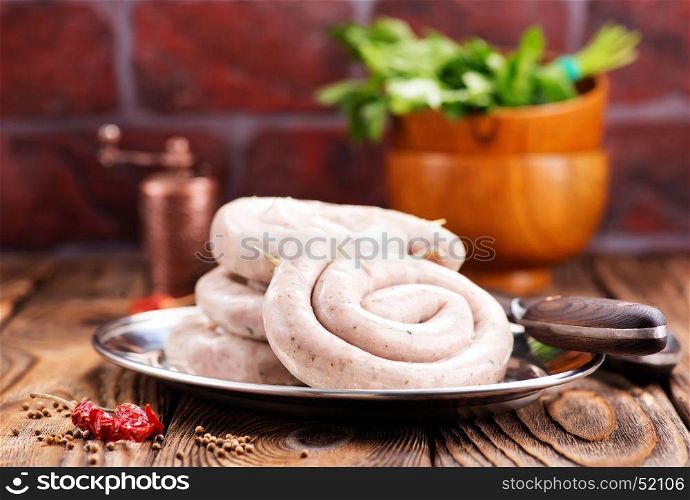 raw sausages with salt and spice on a table