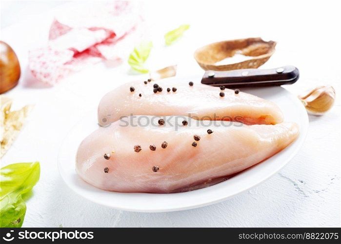 Raw sliced chicken breast fillet steaks on white plate