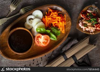 raw soba and fresh vegetables . raw vegetables and sauce on plate