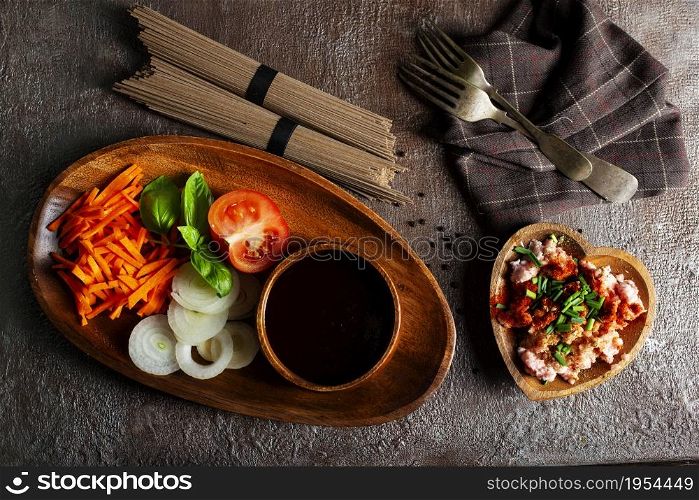 raw soba and fresh vegetables . raw vegetables and sauce on plate