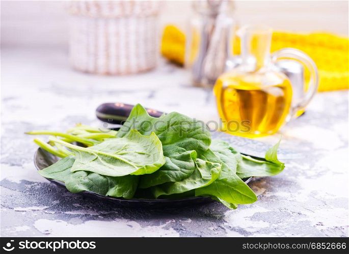 raw spinach on plate and on a table