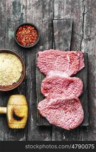 Raw steak for steak. Raw veal chop steak on kitchen Board with spices