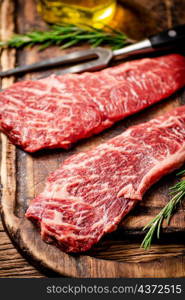 Raw steak on a cutting board. On a wooden background. High quality photo. Raw steak on a cutting board.