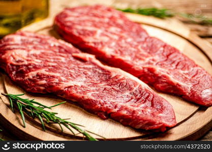 Raw steak on a cutting board. On a wooden background. High quality photo