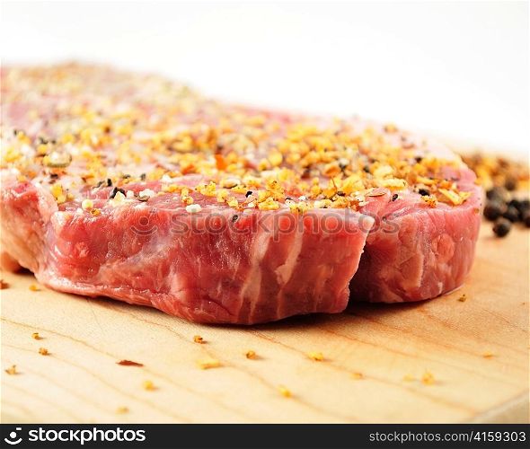 raw steak with spices on a cutting board