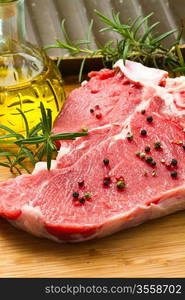 raw T-bone with rosemary and pepper